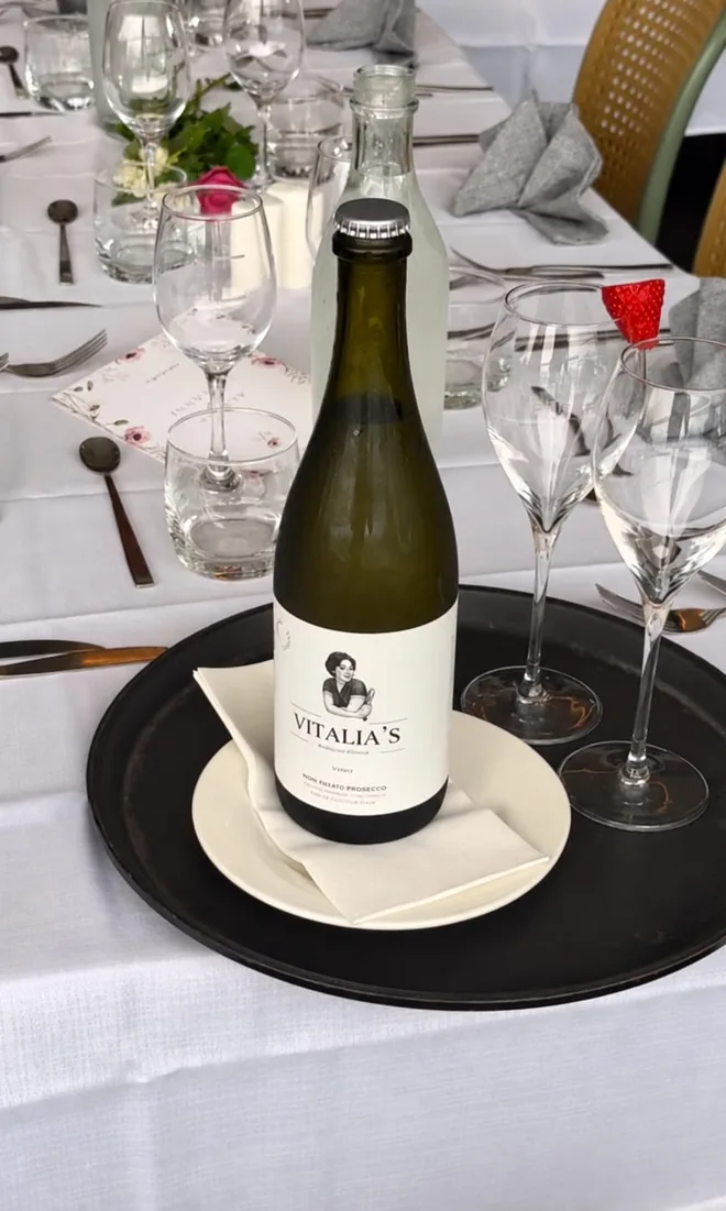 A table laid for a wedding at Vitalia's, with a Vitalia's labelled bottle and glasses