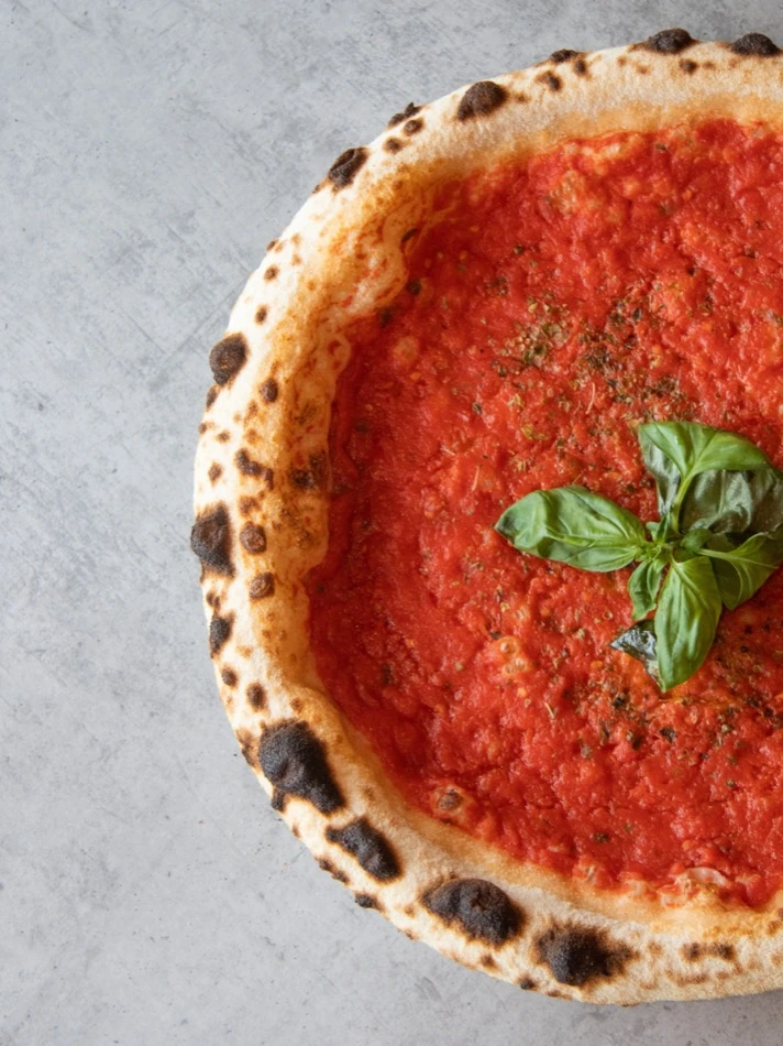 San Marzano tomato base and basil on a Neapolitan pizza